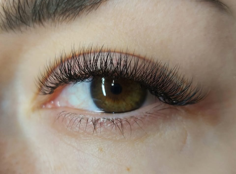 Close-up van een bruin oog met een afgewerkte set wimperextensions